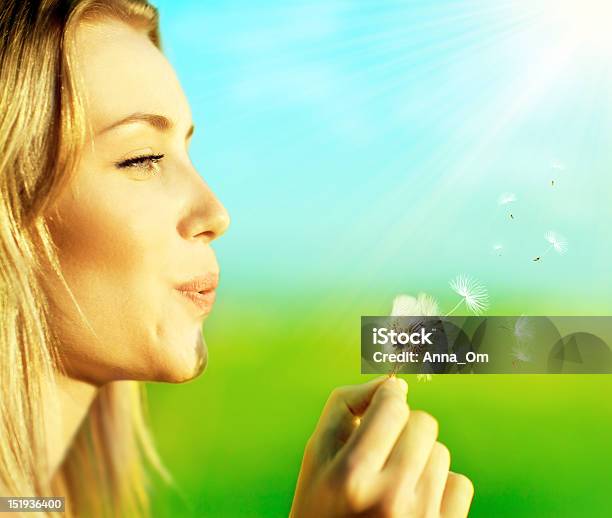 Profile Of A Blonde Happy Beautiful Girl Blowing A Dandelion Stock Photo - Download Image Now