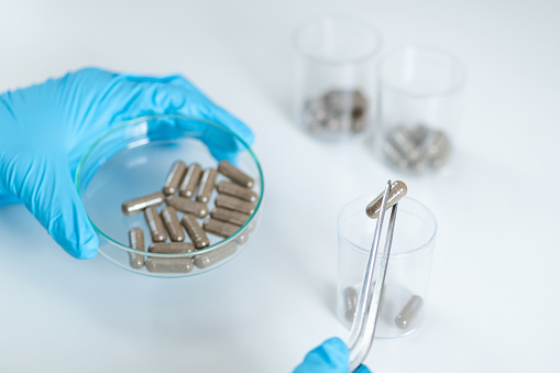 Scientist holds fecal transplant caps in the lab. Witness the forefront of research aimed at revolutionizing healthcare and improving lives