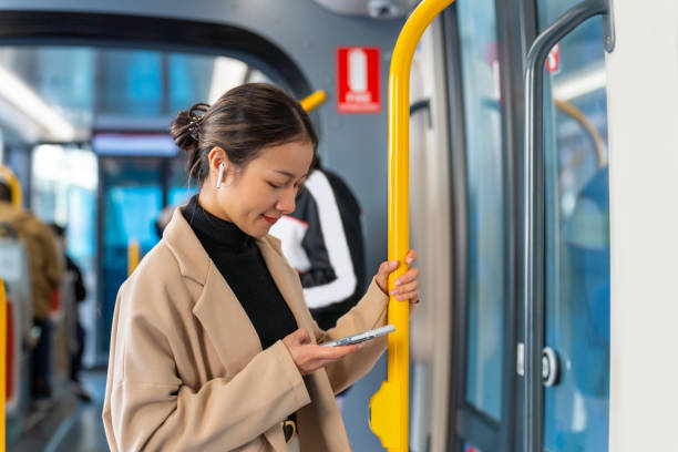 Asian woman using mobile phone on train