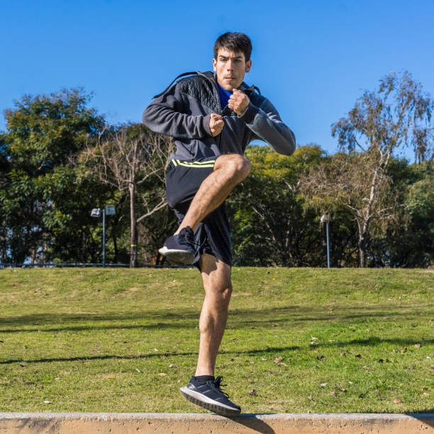 istock Young martial arts fighter practicing kicks in a public park. 1519392628