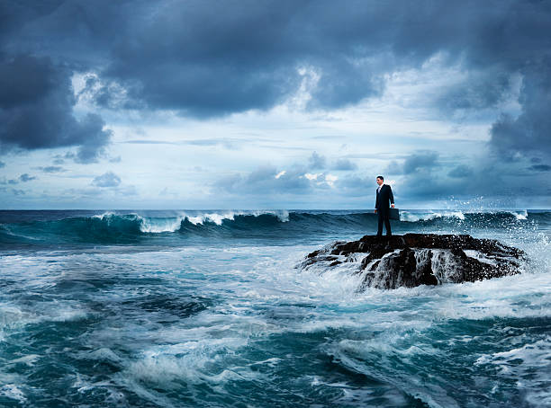 uomo d'affari sulla spiaggia di pioggia - storm sea business uncertainty foto e immagini stock