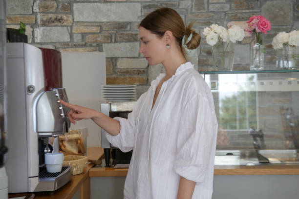 istock Woman making coffee with the coffee machine at self service cafeteria 1519445803