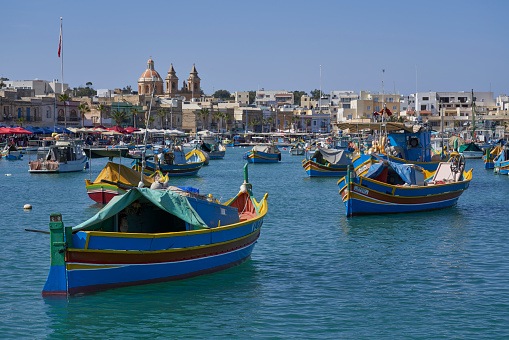 Marsaxlokk, Malta - June 7, 2023: Traditional fishing boats in the harbour of the historic fishing town of Marsaxlokk in Malta
