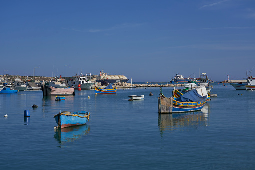 Marsaxlokk, Malta - June 7, 2023: Traditional fishing boats in the harbour of the historic fishing town of Marsaxlokk in Malta