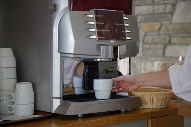 istock Woman making coffee with the coffee machine at self service cafeteria 1519449237