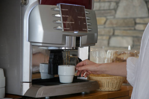 istock Woman making coffee with the coffee machine at self service cafeteria 1519450383