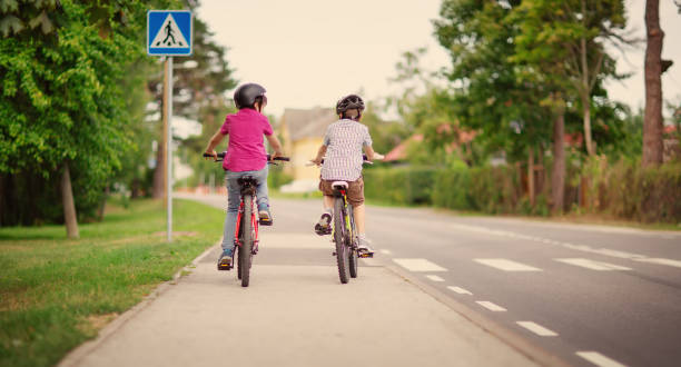 istock Two boys riding on their bicycles along an asphalt road 1519454303