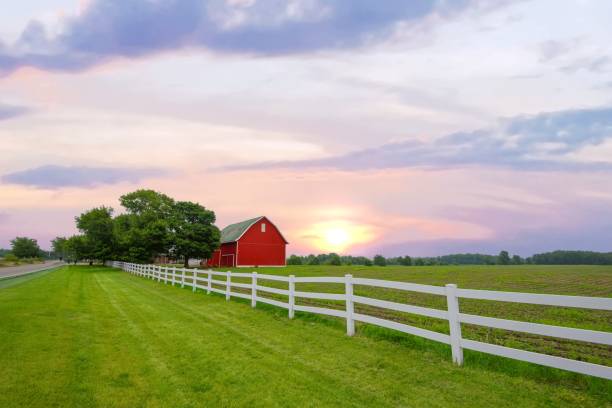 Red Barn with white fence at sunrise- Northern Indiana stock photo
