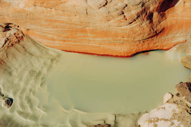 Water hole in rocks and mud in desert after rain season