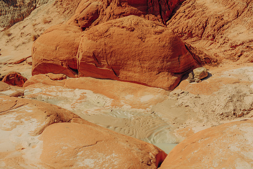 Water hole in rocks and mud in desert after rain season