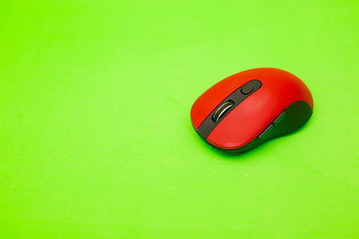 Red wireless computer mouse on Green background with clipping path