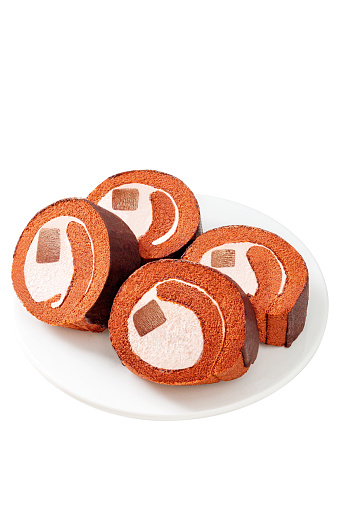 Chocolate swiss cake roll, on a tabletop on a white background, indoors, close-up