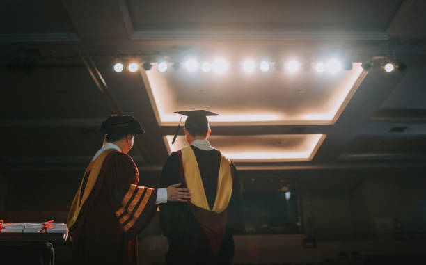 istock Convocation ceremony rear view Asian Graduation university student together with Dean standing on stage for photograph session in a row 1519542535