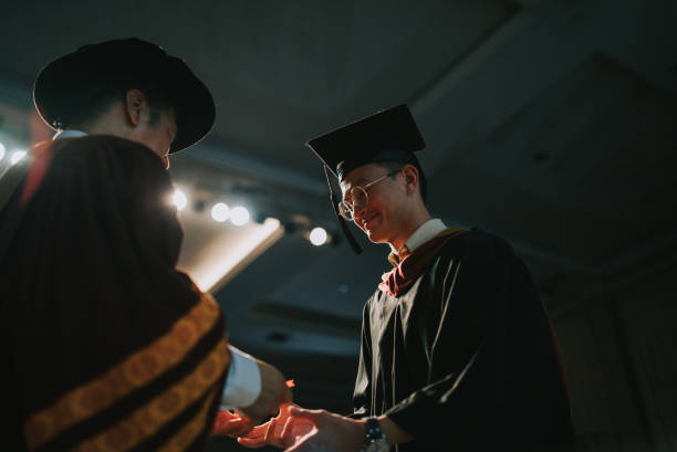 istock Convocation ceremony Asian Dean hand over Graduation university student graduation scroll on auditorium stage 1519543068