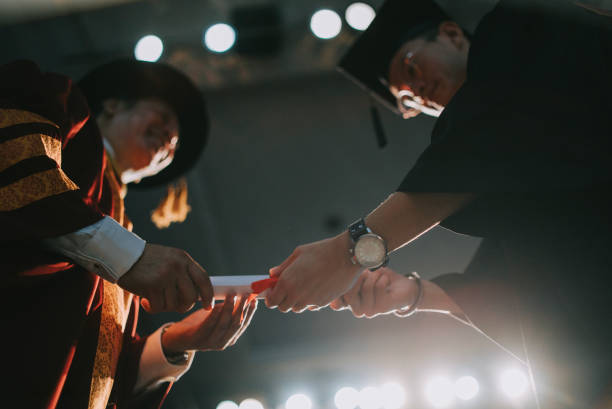istock Convocation ceremony Asian Dean hand over Graduation university student graduation scroll on auditorium stage 1519543618