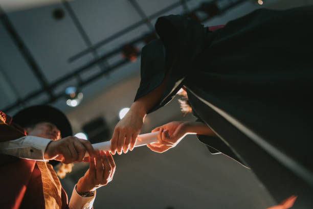 istock Convocation ceremony Asian Dean hand over Graduation university student graduation scroll on auditorium stage 1519543635