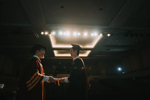 istock Convocation ceremony Asian Graduation university student receiving graduation scroll from Dean on Auditorium stage 1519543653
