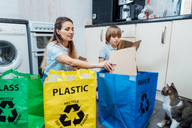 istock Mother is teaching kid how to recycle help the boy aware environmental importance - mom educates son sort garbage into different bins on kitchen. Family sorting garbage at home. Concept of recycling. 1519560472