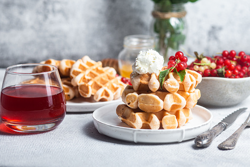 Belgian waffles with red currants in a bowl