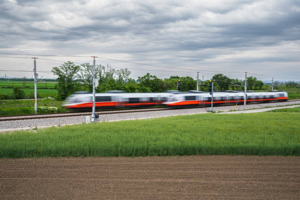 istock Two Passing Commuter Trains in Rural Landscape With Clouds 1519591540