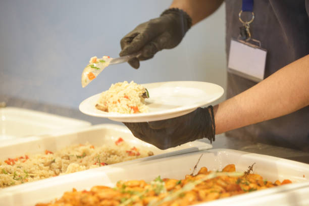 istock Buffet style service - Canteen worker at serving line putting food on the plate 1519601270