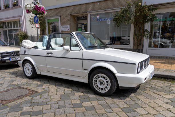 Happy bride and groom, newlywed wedding couple is driving a convertible retro car with balloons on a country road for honeymoon after the ceremony. Way. The best day and marriage. Just married.