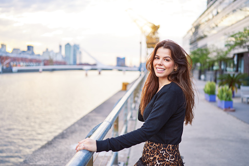 portrait beautiful latin american woman looking and smiling happy in exterior of Puerto Madero