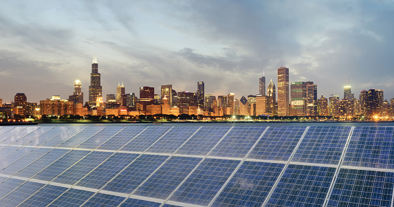 Solar Power Station over urban skyline at night. The city is Chicago, USA.