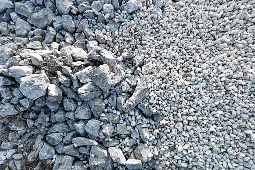 Top view, crushed rock at construction site. Small and medium-sized stone ground for building material gravel texture. Garden gravel stone landscaping. Grey color background. Rough surface. Abstract