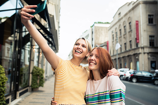 Two cheerful friends are hanging out outside