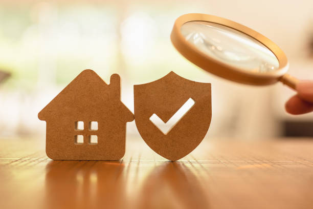 Hand holding magnifying glass and looking at house and shield protect icon, The concept of finding the right insurance for the right lifestyle of each person, health insurance, home, car, savings. stock photo
