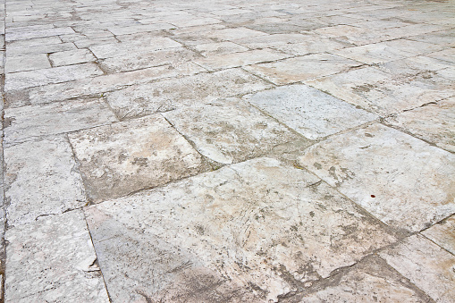 Old white limestone paving made with stone blocks of rectangular shape in a pedestrian zone