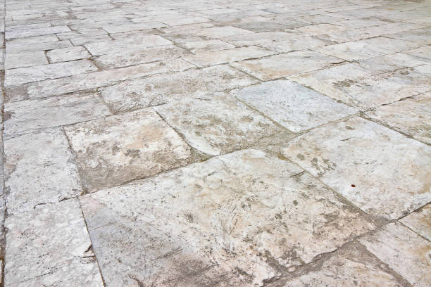 Old white limestone paving made with stone blocks of rectangular shape in a pedestrian zone stock photo
