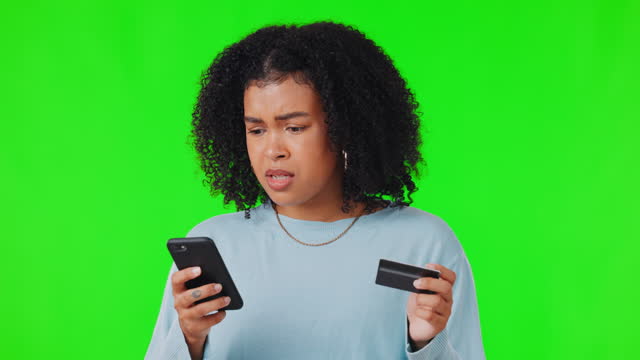 Confused, phone and woman with credit card on green screen for purchase, payment or internet banking. Ecommerce, online shopping and worried female person on smartphone for finance debt in studio