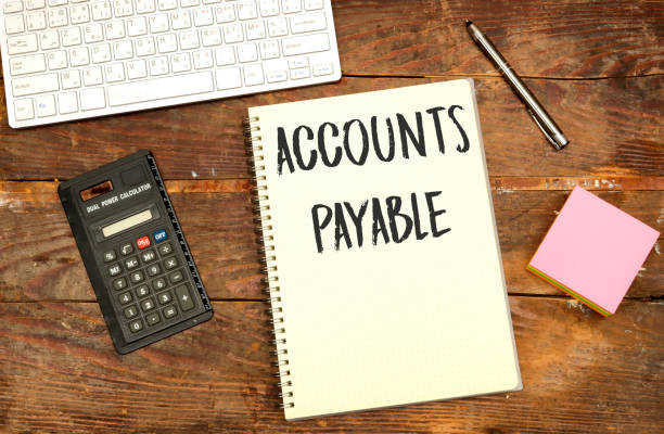 istock Business concept. notebook with text ACCOUNT PAYABLE , near calculator and keyboard on wood table 1519822523