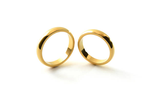istock Engagement gold rings standing next to each other white background 1519823055