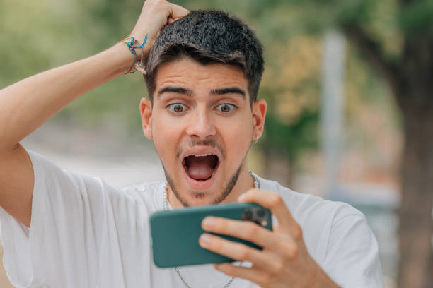 istock scared or surprised young man or student looking at mobile phone 1519866031