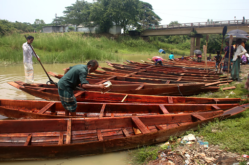 Floating weekly market selling and buying wooden boats in Salutikar. Sylhet, Bangladesh, 13 June 2023.