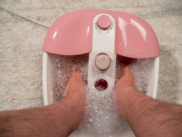 istock Men's legs in a vibrating foot massager. Electromassage foot bath. Relax after work. 1519888239