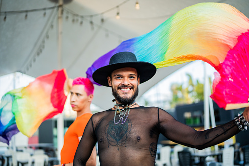 Portrait of young man with gay pride flag on a festival