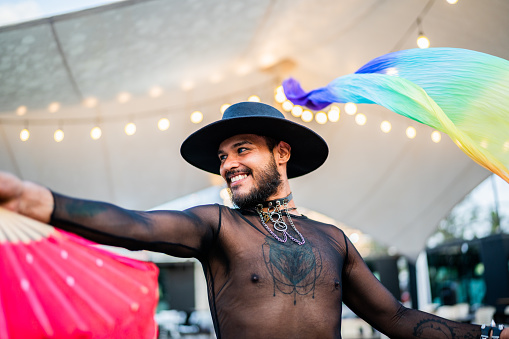 Young man waving pride flag on a gay festival