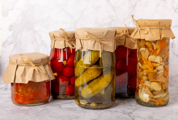 istock Jars of pickled vegetables cucumbers, tomatoes, mushrooms and eggplants on a light textural background. Pickled and canned foods. Copy space. Place for text. 1519945033
