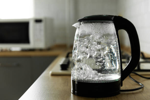 istock Modern electric transparent kettle on a wooden table in the kitchen.Kettle for boiling water and making tea.Home appliances for making hot drinks.Space for copy.Place for text. 1519945901