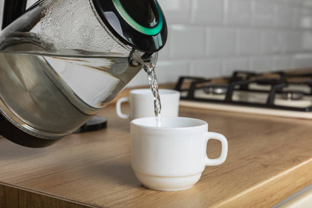 istock Modern electric transparent kettle on a wooden table in the kitchen.Kettle for boiling water and making tea.Home appliances for making hot drinks.Space for copy.Place for text. 1519945906