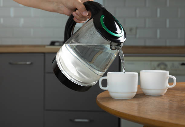 istock Modern electric transparent kettle on a wooden table in the kitchen.Kettle for boiling water and making tea.Home appliances for making hot drinks.Space for copy.Place for text. 1519945913