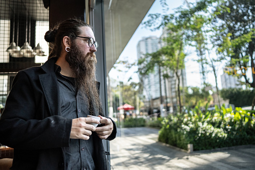 Mid adult man contemplating at coffee shop