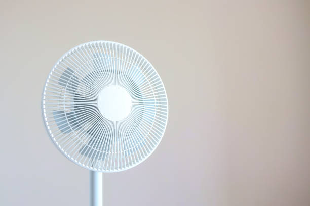 White desktop electric fan on light white background. Minimal concept with copy space.