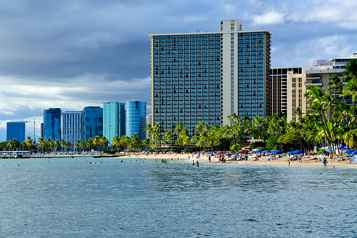 Waikiki, Honolulu, Oahu, Hawaii, USA: looking west along the beach and Fort DeRussy Boardwalk / Beach Park - Rainbow Tower in the center.