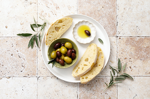 Olives, olive oil and ciabatta, top view