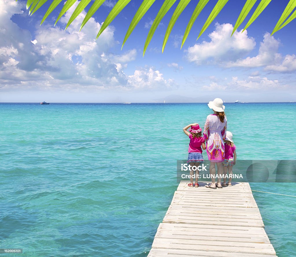 Figli e madre in Molo sulla spiaggia tropicale - Foto stock royalty-free di Famiglia